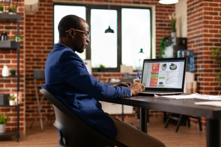 African american person using laptop to work on business charts and financial growth