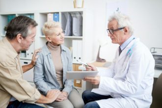 Doctor giving advice to mature woman with serious disease