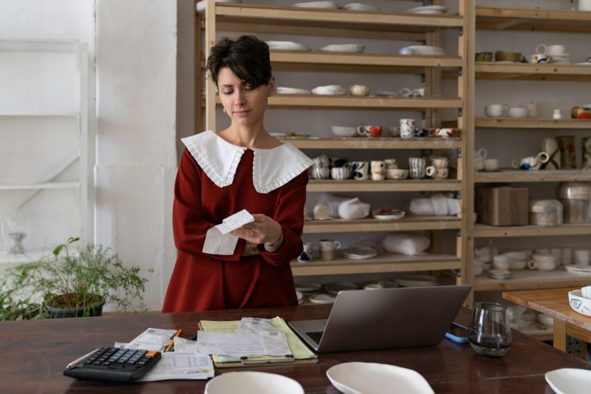 Female pottery shop owner looking at bill thinking how to make business more profitable