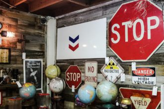 Old used road signs and traffic signs sold for home decor in antique retail store.