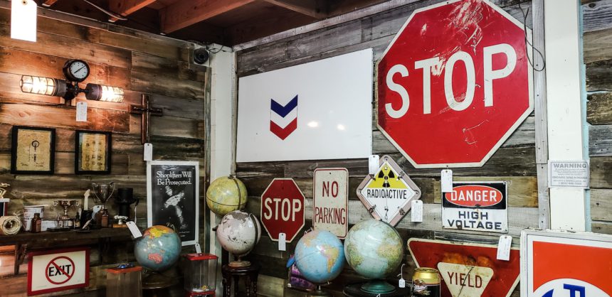 Old used road signs and traffic signs sold for home decor in antique retail store.