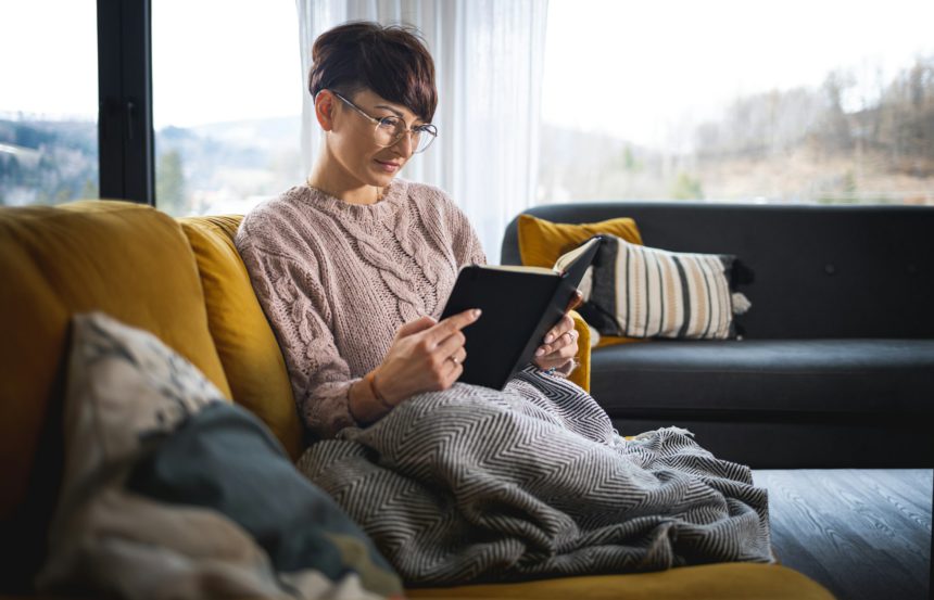 Reading a book in cozy living room and on comfortable sofa