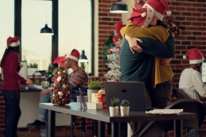 Startup employees celebrating winter holiday in festive office