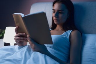 Woman reading book in bed