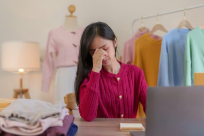 Worried asian female entrepreneur experiencing stress while managing her online